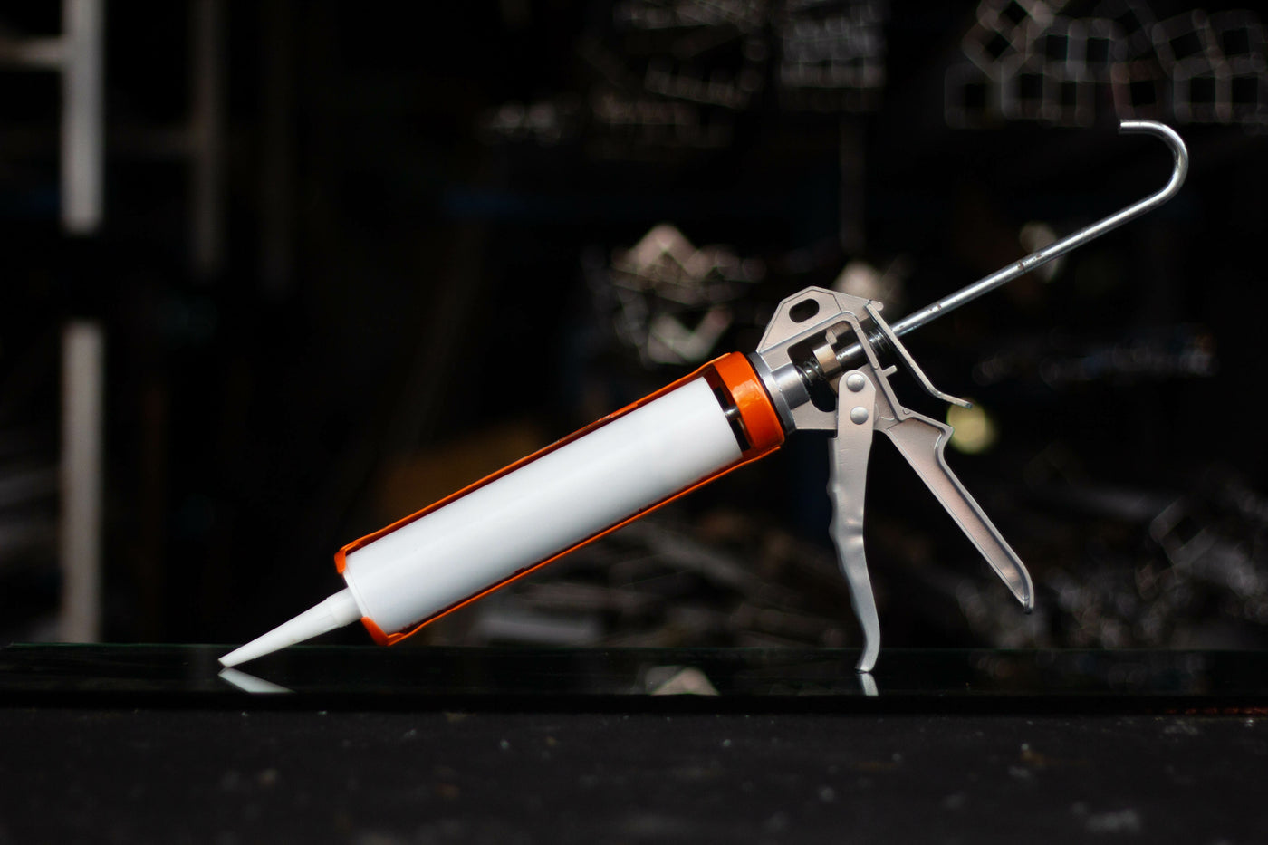 A sealant tube within an applicator sits on a desk ready to be used.